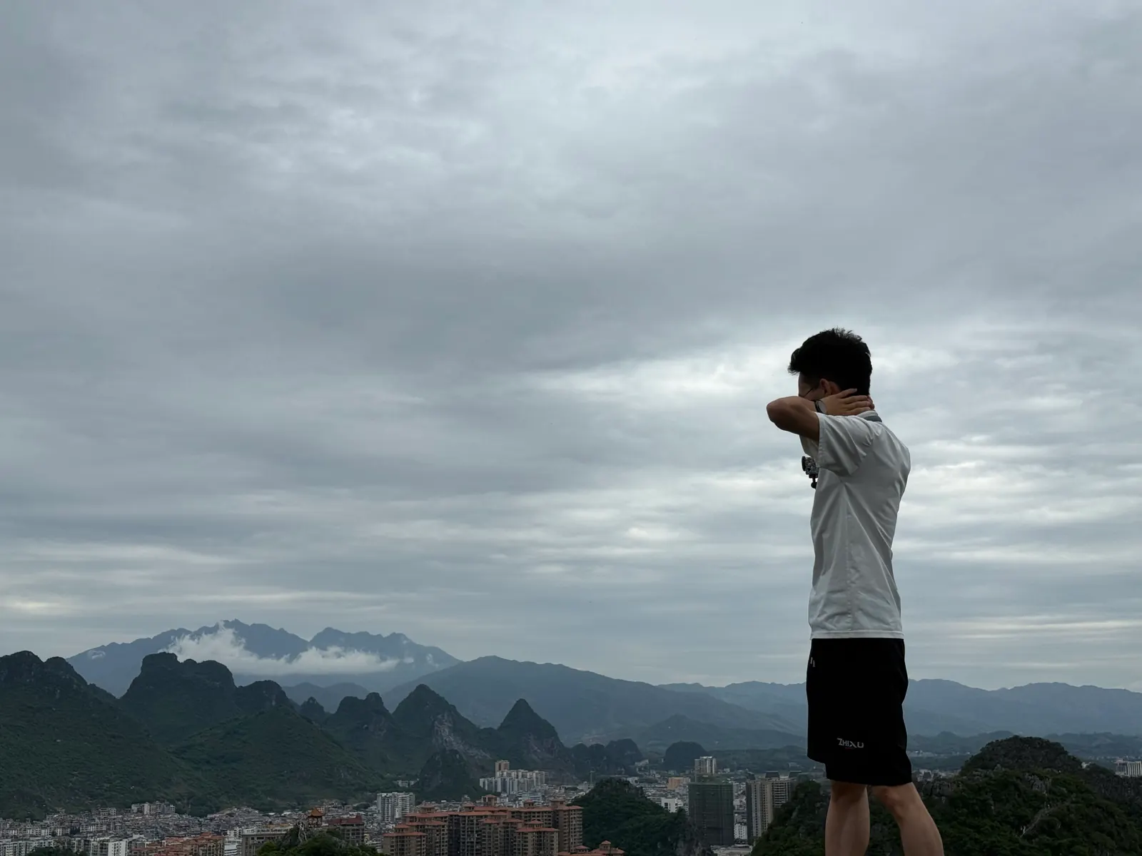 LuoZhuo 站在山顶眺望群山和城市