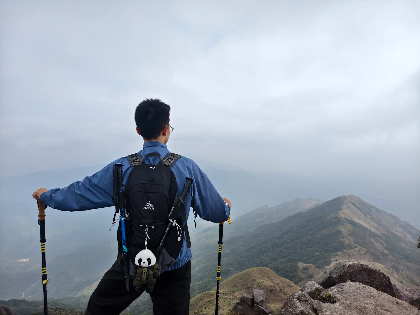 徒步者背对镜头眺望远处群山