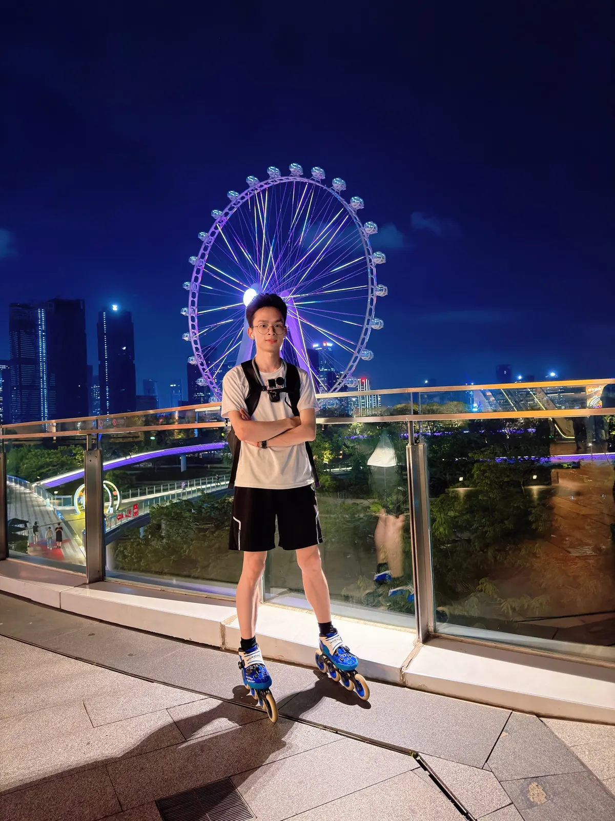 LuoZhuo 穿着轮滑鞋站在夜晚的摩天轮前
